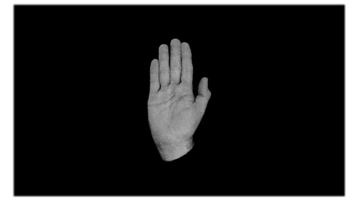 A black and white image of a disembodied hand up in a "stop" gesture.