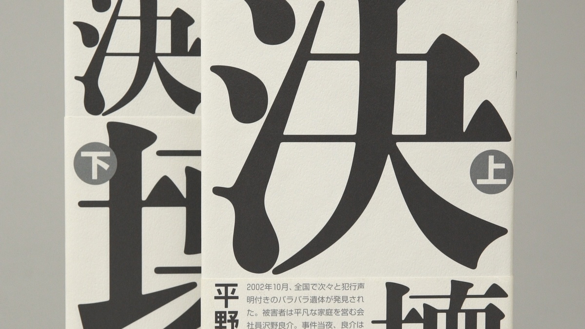 A close-up of a book cover with large black Japanese characters on white textured paper.