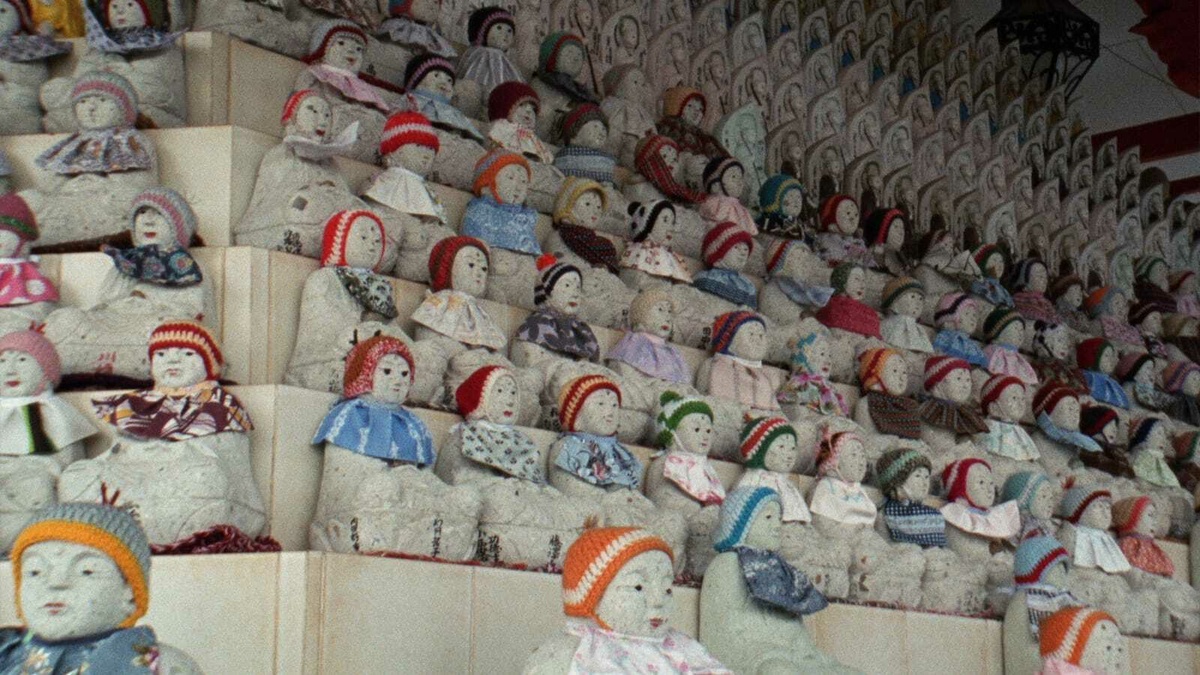 Rows of sculpted human figures wearing knitted hats and garments.