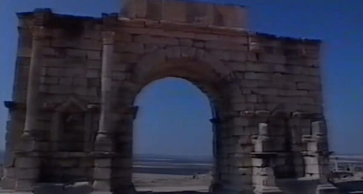 A brick arch with a night blue sky behind it.