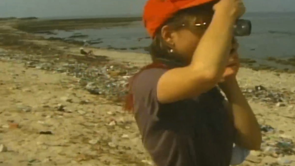 A.MAL resident on a beach holding a camera