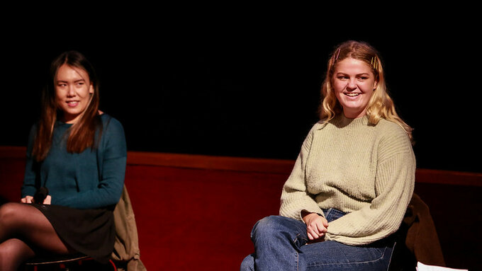 Two people speaking on a panel.