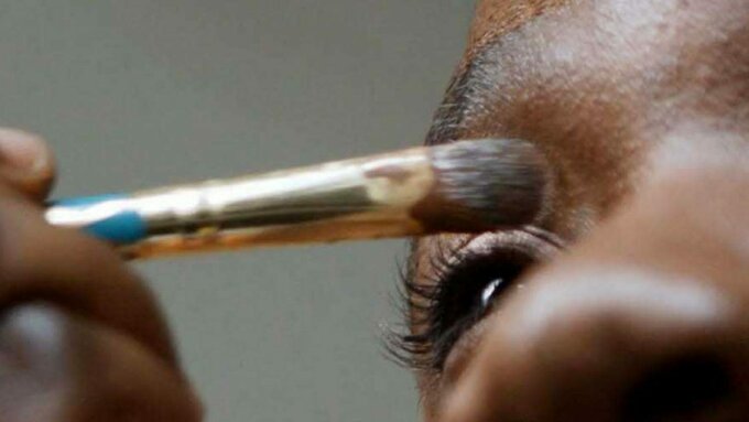 A close up of a person applying eye shadow.