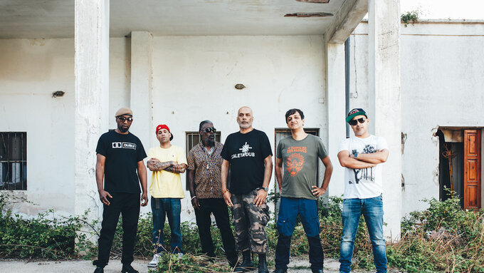 Six people stand in a row outside a building.