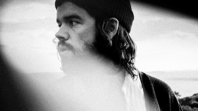 A black and white photo of a person with a beard.