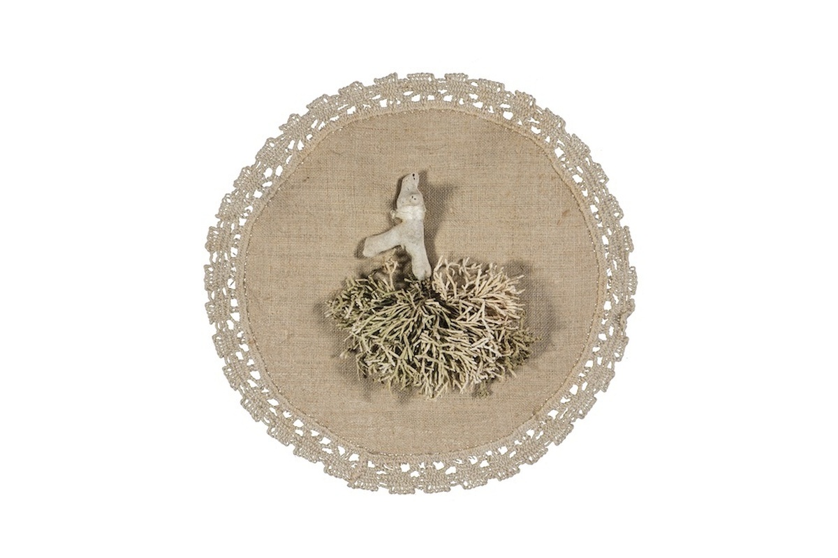 An embroidered circle of fabric with decorative edges, and a fabric root in the centre. The root looks similar to a lung