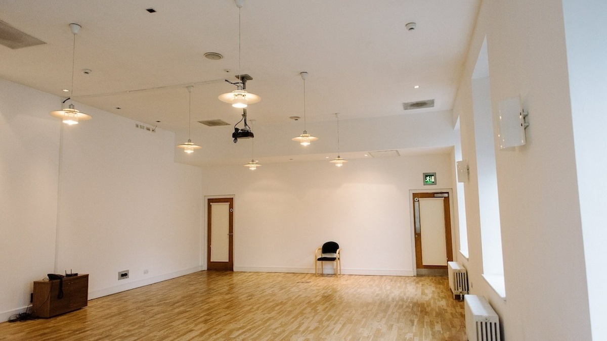 A photograph of the CCA's clubroom, a room with white walls and laminate flooring.