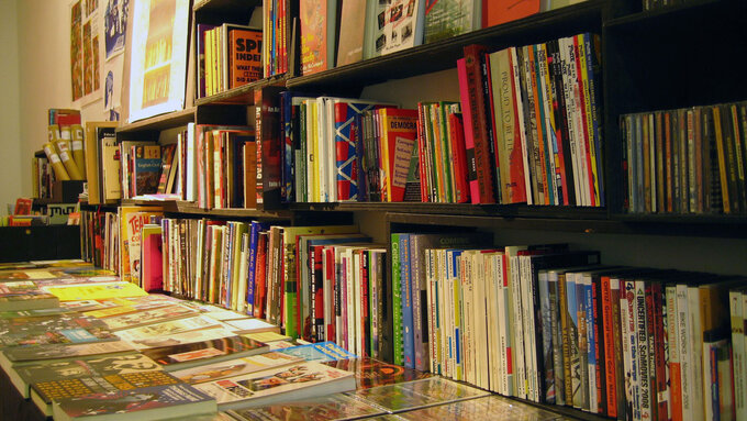 Books of different sizes laid out on shelves and tables.