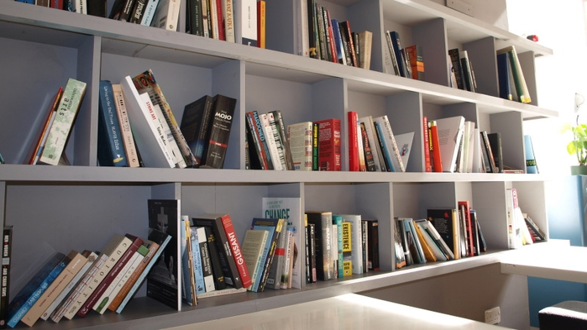 A photograph of the reading library in CCA foyer, featuring shelfs full of books.