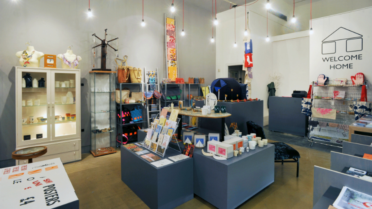 An image of the Welcome Home shop with grey shelves covered in cards, jewellery and other items.
