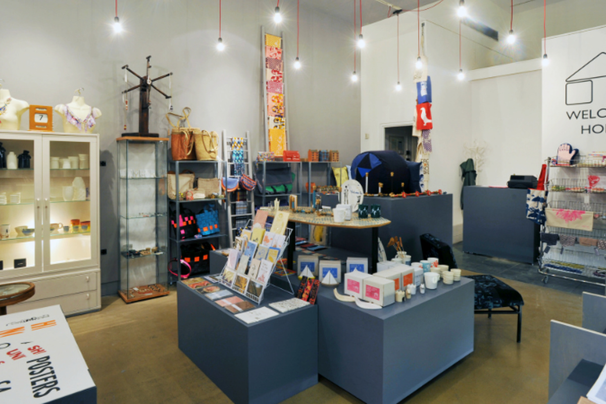 An image of the Welcome Home shop with grey shelves covered in cards, jewellery and other items.